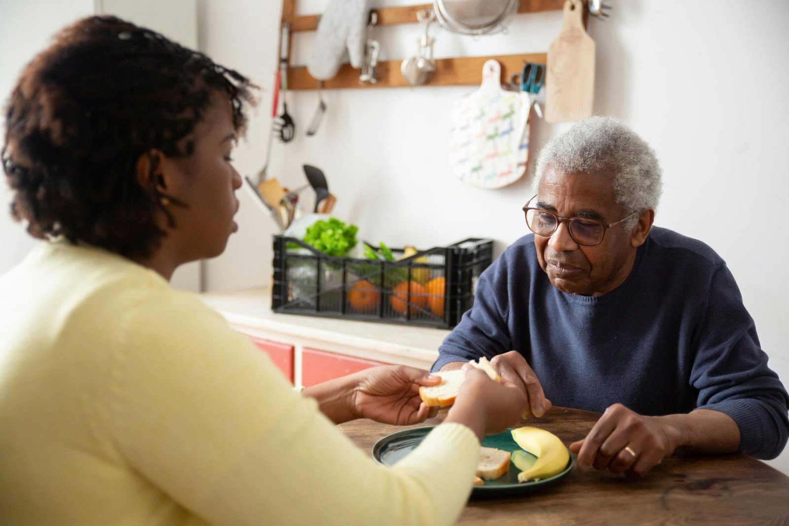 Caregiver connecting with senior during meal time.